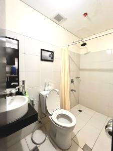 La salle de bains est pourvue de toilettes et d'un lavabo. dans l'établissement Mey’s Condo in Pasig - 1BR with Balcony, à Manille