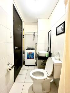 a bathroom with a toilet and a sink at Mey’s Condo in Pasig - 1BR with Balcony in Manila