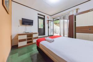 レンバンにあるRedDoorz near Cikole Lembangのベッドルーム(大型ベッド1台、テレビ付)