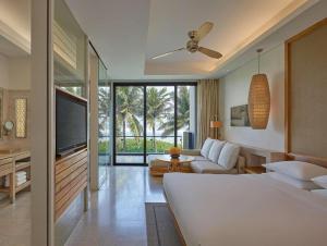 uma sala de estar com uma cama branca e uma televisão em Villa seaview and apartment Da Nang Resort by JT group "Free pick up" em Da Nang