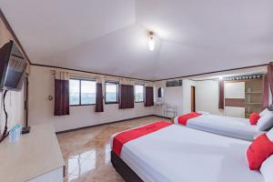 レンバンにあるRedDoorz near Cikole Lembangのベッド2台とテレビが備わるホテルルームです。