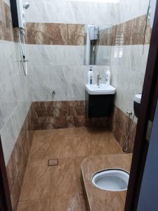 ein Bad mit einem Waschbecken und einem WC in der Unterkunft D'Rusa Homestay in Port Dickson