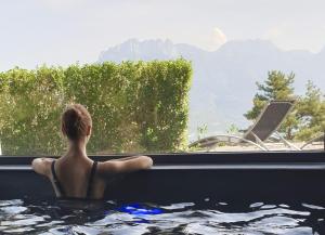 サン・ジョリオにあるLes Ô d'Annecyの窓を見下ろすバスタブに座る男