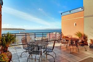 a patio with tables and chairs on a balcony at Belltown Court Sunset Suite in Seattle