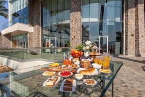 un buffet de comida en una mesa de cristal frente a un edificio en StayVista's Emerald Acres offering a heated pool, bonfire, snooker table, scenic views, tennis court, steam room, gazebo, & gym, en Lonavala