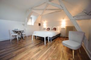 two people sitting on a bed in a room at Villa Clément Sens Appart'Hotel in Sens