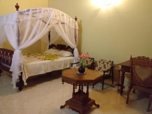 a bedroom with a bed with a canopy at Sujee Villa White House in Beruwala +42 photos