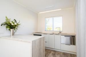 a white kitchen with a counter and a sink at Amuri Villas in Clive