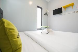 Un pat sau paturi într-o cameră la Urbanview Hotel Arafuru Residence Duren Sawit