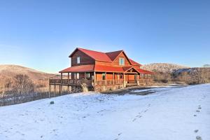 une maison avec un toit rouge dans la neige dans l'établissement Spacious Slaty Fork Home about 12 Mi to Snowshoe, à Slaty Fork