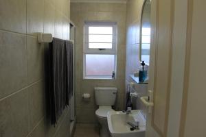 a bathroom with a toilet and a sink and a window at Wees Gerus in Yzerfontein
