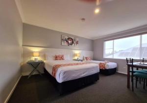 a hotel room with two beds and a window at Marco Polo Motor Inn Taree in Taree