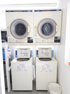 three washing machines and a washer and dryer in a room at Shima Stay holoholo in Zamami