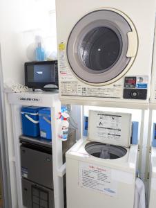 a microwave and a washing machine in a room at Shima Stay holoholo in Zamami