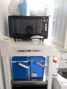 a microwave sitting on top of a shelf in a refrigerator at Shima Stay holoholo in Zamami
