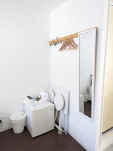 a bathroom with a toilet and a mirror at Shima Stay holoholo in Zamami
