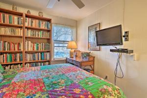 1 dormitorio con 1 cama, TV y libros en Cozy Garrison Home, 11 Mi to Bear Mountain! en Garrison