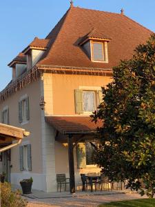 a house with tables and chairs in front of it at Domaine de Suzel in Vignieu