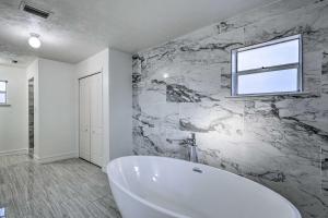 a white bath tub in a bathroom with a window at Spacious Family Home w/ Backyard in Gainesville! in Gainesville +31 photos