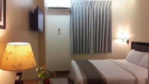 A bed or beds in a room at Grand Laurel Hotel