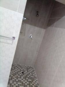 eine Dusche im Bad mit Fliesenboden in der Unterkunft Paul & Mollie's Guest House in Brits