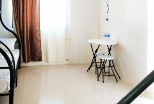 uma pequena mesa e dois bancos num quarto em L and V Bantayan Guest House em Ilha de Bantayan