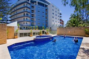 a swimming pool in front of a building at Sandy Cove Apartment The Entrance 12 in The Entrance