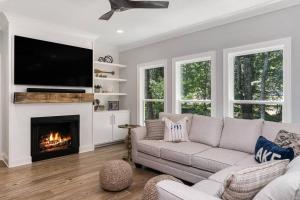 a living room with a couch and a fireplace at New Home, Dock, Home Theatre Projector, Hot Tub, Fire Pit, Kayaks in Winchester