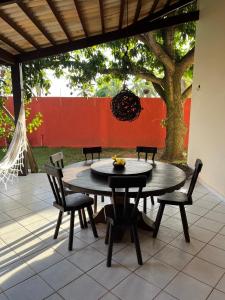 einen Tisch und Stühle auf einer Terrasse mit einem Baum in der Unterkunft Casa Pirambu in Pipa