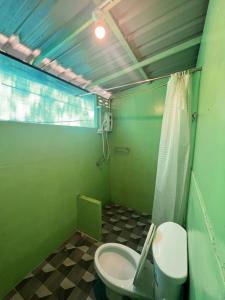 La salle de bains verte est pourvue de toilettes et d'une douche. dans l'établissement LONELY GROOVE, à Ko Chang