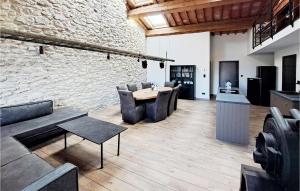 Zimmer mit Stühlen, einem Tisch und einer Steinmauer in der Unterkunft 4 Bedroom Beautiful Home In Pennautier in Pennautier
