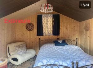 ein Schlafzimmer mit einem Bett und einem Stuhl darin in der Unterkunft Chalet chez Jules in Asuel