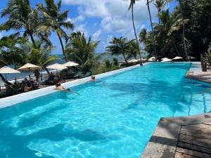 ein Pool in einem Resort mit Menschen im Wasser in der Unterkunft Casa Pirambu in Pipa