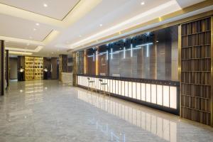 a lobby of a hotel with a glass wall at Jiuzhaigou Cloudy Hotel in Jiuzhaigou