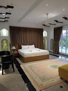 a bedroom with a bed and a desk and a chair at Valley CLIFF INN in Al Jināh