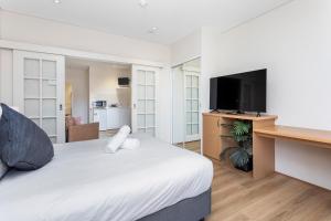 1 dormitorio con 1 cama y escritorio con TV en Perth Cbd Retreat Victoria Ave 1br Apt en Perth