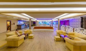 a lobby with couches and a stage in the background at Holiday Park Resort - Ultra All İnclusive in Okurcalar