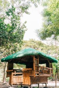 a gazebo with a green roof and chairs at Family Dome Glamping in Rizal with Private Hotspring in Lubo