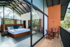 Un dormitorio con una cama y una mesa en el balcón. en Crystal Kuruva Nature Resort & Spa, en Wayanad