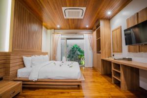 普吉市的住宿－Malabar Pool Villa Phuket，卧室配有白色的床和电视。