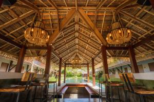 Malabar Pool Villa Phuket في فوكيت تاون: مطعم فيه ثريا وطاولات وكراسي