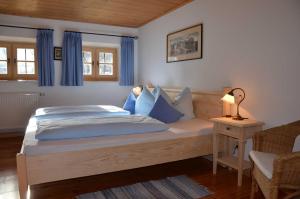 a bedroom with a large bed with blue pillows at Ferienwohnungen Budererhof in Bad Wiessee