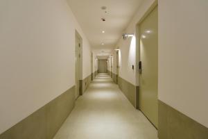 an empty corridor of a hospital hallway with white walls and a long aisle at Yangju Hotel Ippda in Yangju