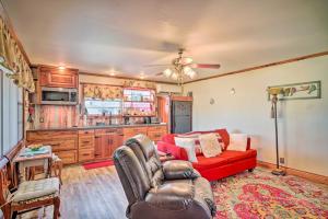 a living room with a red couch and a kitchen at Cozy Lake Charles Studio with Golf Course Views in Lake Charles