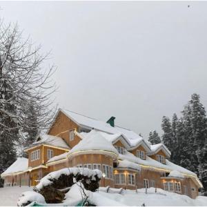 a large house with snow on top of it at Gulmarg Ski Hill Resort in Gulmarg