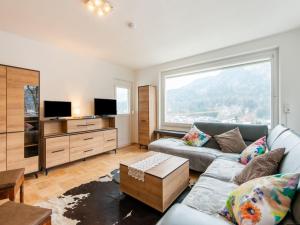 a living room with a couch and a tv at Beautiful Holiday Home in Feldkirch with Garden in Feldkirch