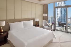 a bedroom with a large white bed and a large window at Address Fountain Views in Dubai