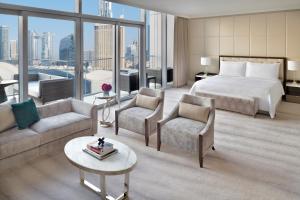 a hotel room with a bed and a couch and chairs at Address Fountain Views in Dubai