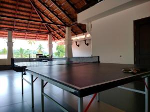 a ping pong table in the middle of a room at Wayanad Mace Mansion in Kenichira