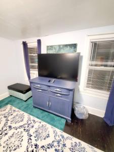 Room in Apartment - Blue Room in Delaware في دوفر: خزانة ملابس زرقاء مع تلفزيون بشاشة مسطحة في الغرفة
